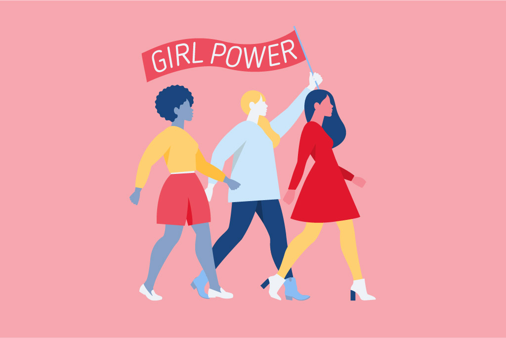 Three women celebrating Women's Day by marching and holding a banner saying girl power