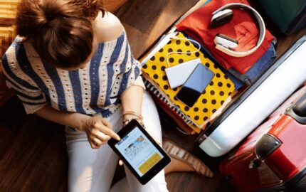 a traveller next to her bag booking a holiday